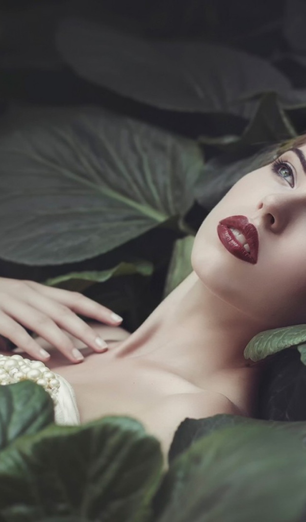 Девушка лежит в больших листьях