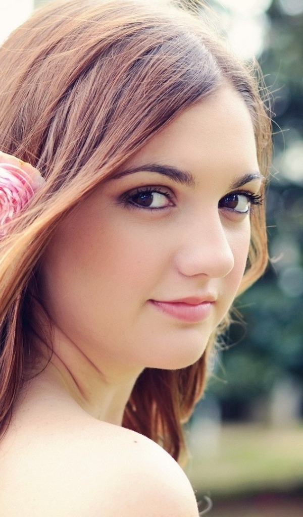 Девушка модель с розовым цветком в волосах