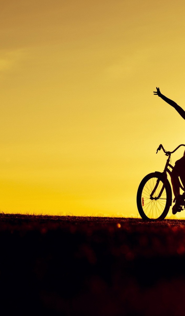 Девушка на велосипеде на фоне заката