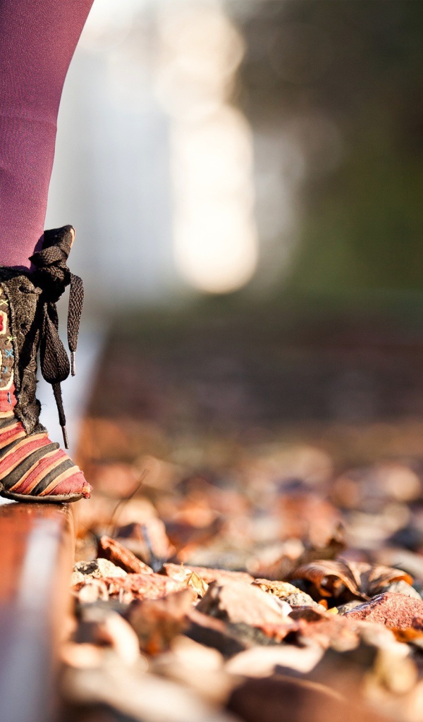 Девушка на носочках на рельсе