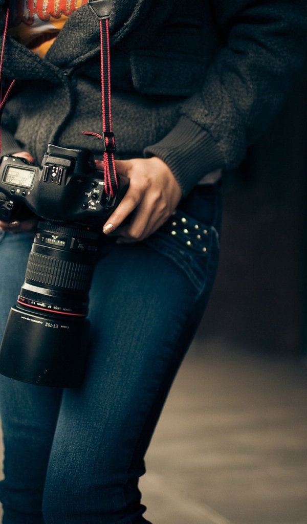 Девушка фотограф с профессиональным фотоаппаратом Canon