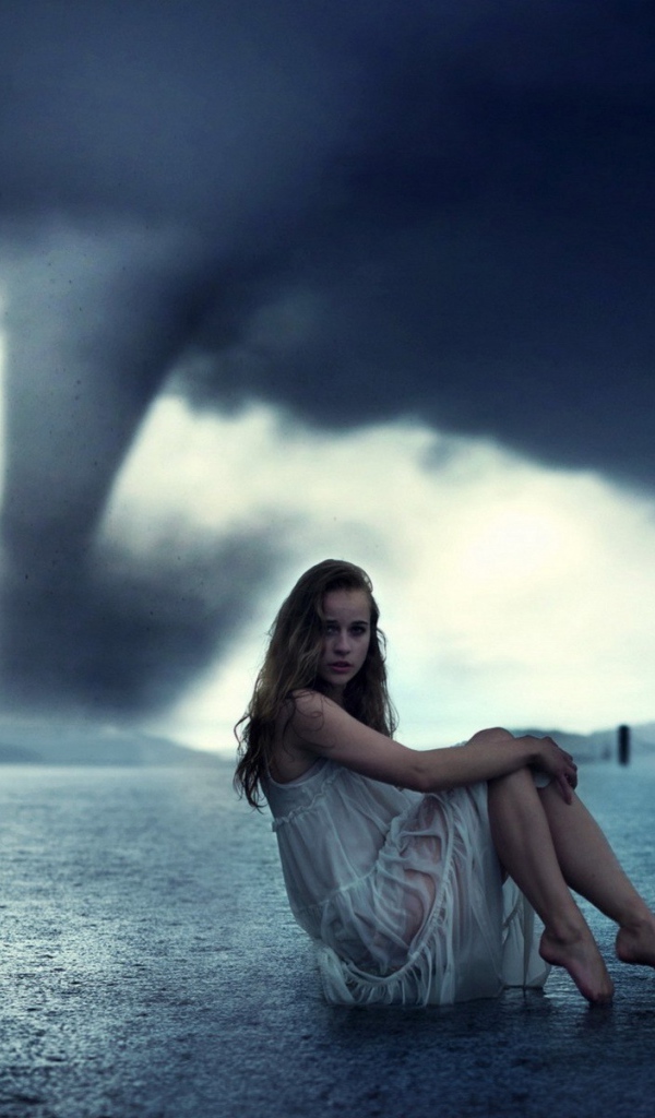 Девушка позирует на фоне торнадо