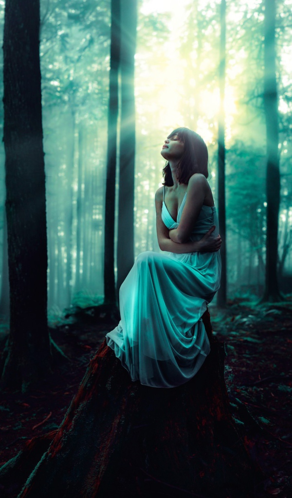 Девушка сидит на старом пеньке