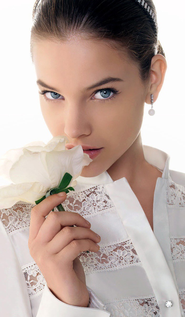 Девушка нюхает белый цветок