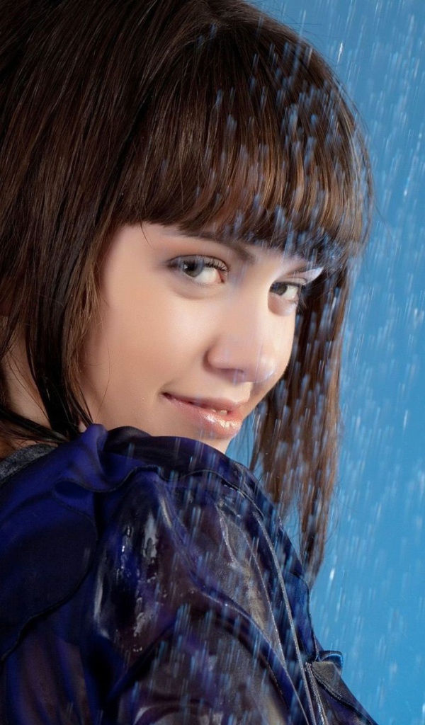 Девушка стоит под струей воды