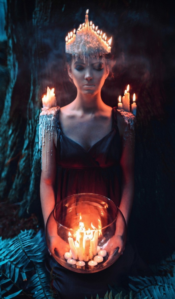 Девушка в окружении свечей в лесу