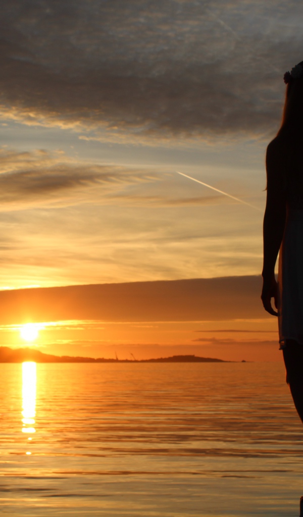 Девушка смотрит на закат в Норвегии