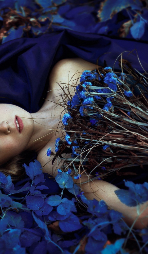 Девушка с букетом среди синих цветов