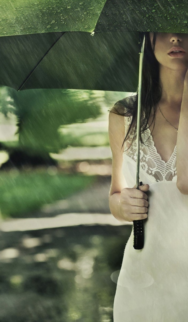 Девушка под зеленым зонтом во время дождя