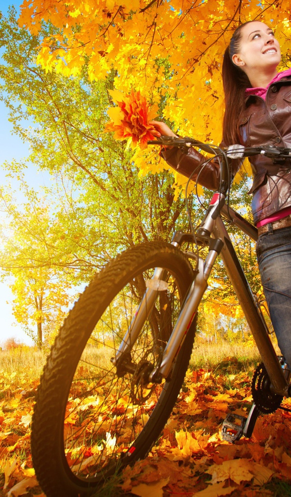 Девушка с велосипедом на осенней прогулке