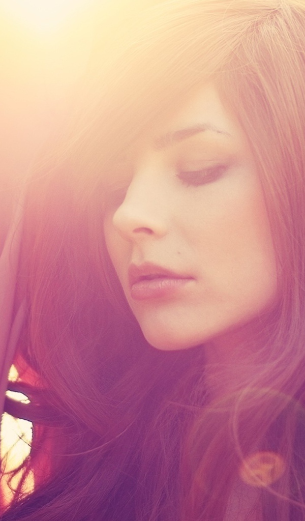 Девушка с каштановыми волосами в лучах солнца