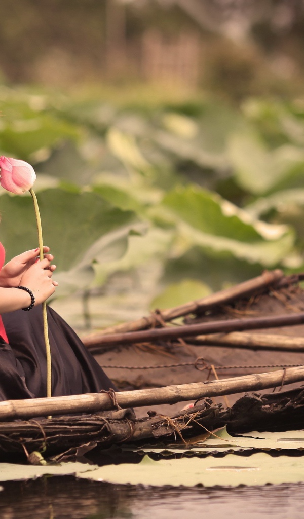 Девушка с цветком сидит в лодке