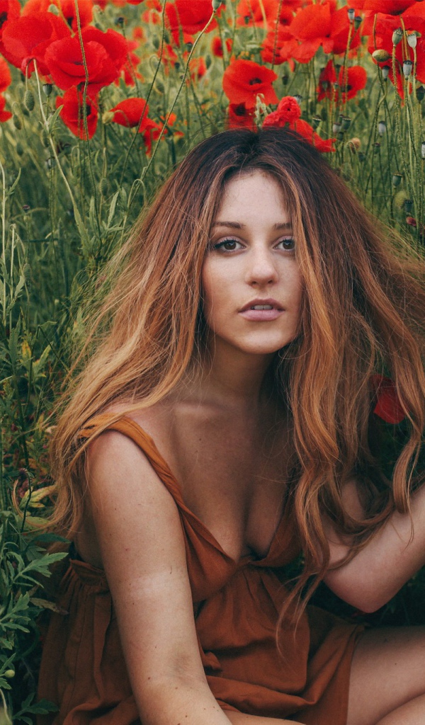 Девушка с распущенными волосами среди цветов мака
