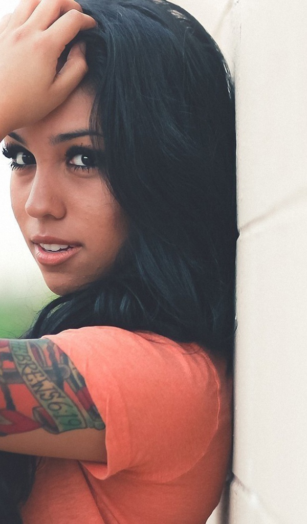 Страстная длинноволосая брюнетка прислонилась к стене