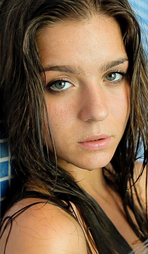 Зеленоглазая брюнетка стоит в душе