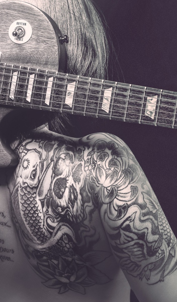 Гитара на спине татуированной девушки