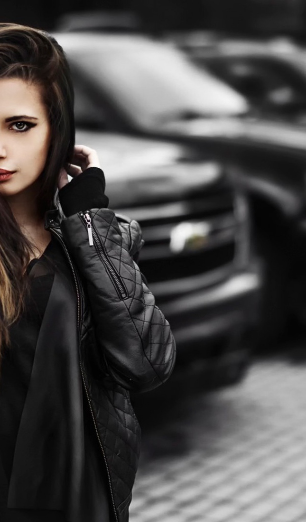 Черноволосая девушка на фоне черных автомобилей