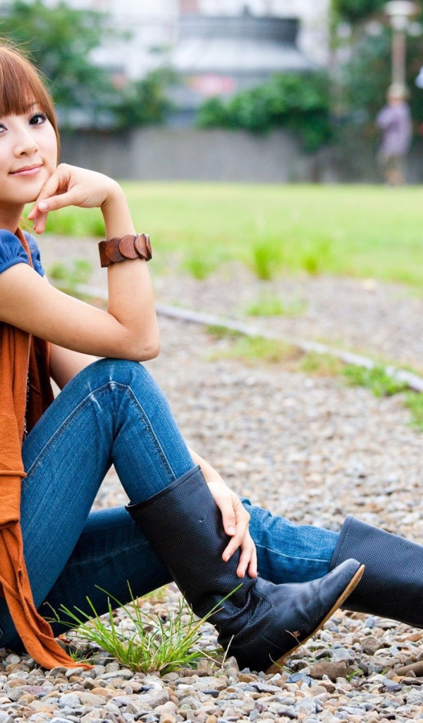 Японская девушка сидит на трамвайном пути