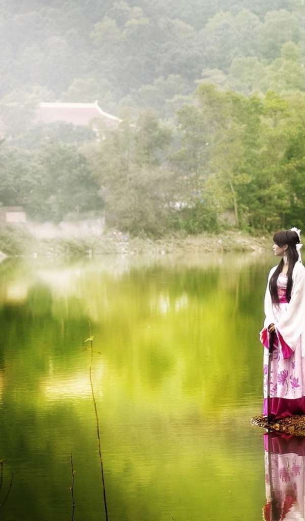 Японская девушка стоит на берегу водоема