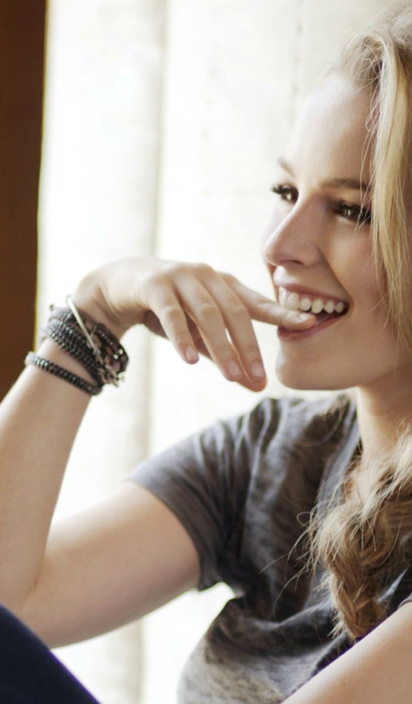 Смеющаяся блондинка приложила палец к губам