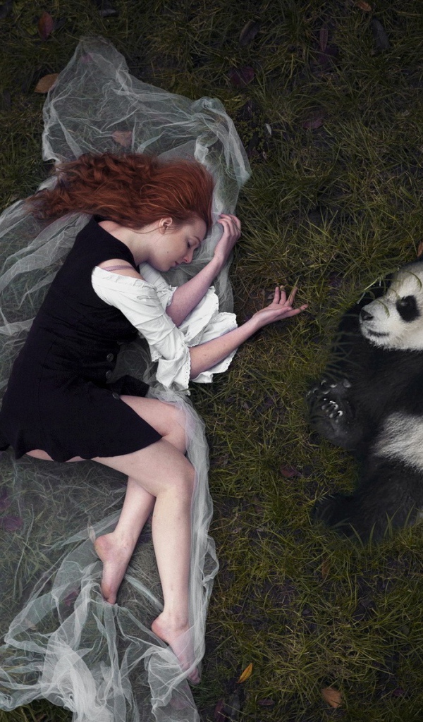 Девушка и панда лежат рядом на траве