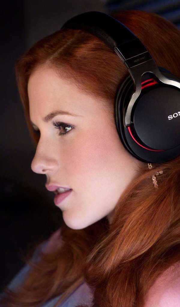 Рыжеволосая девушка слушает музыку