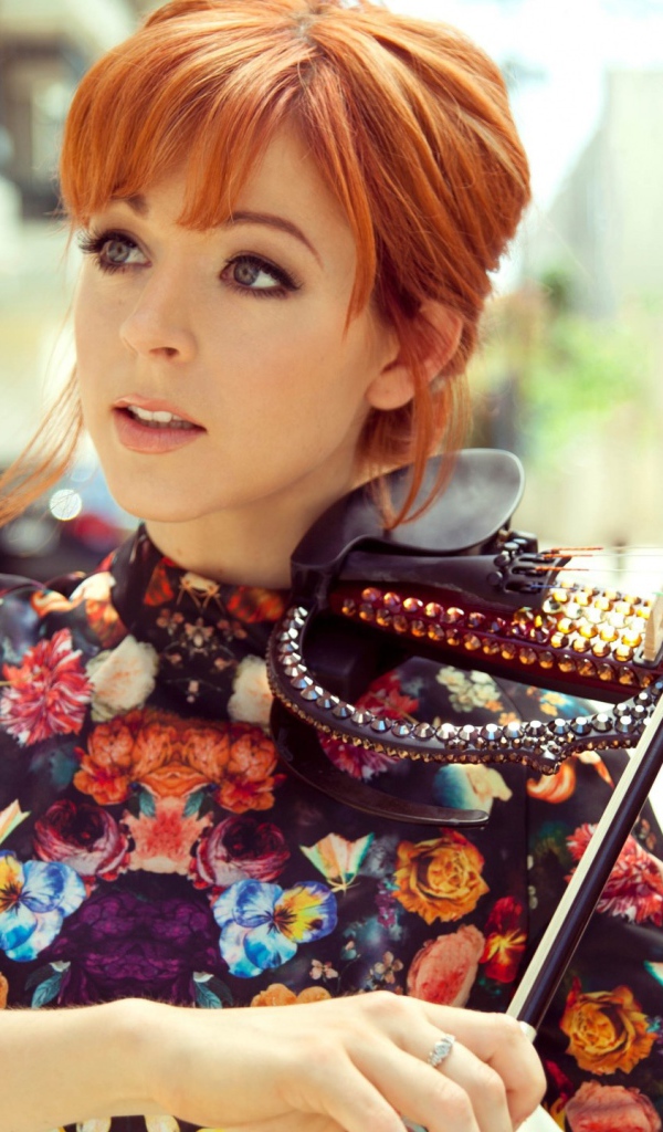 Рыжая девушка играет на скрипке со стразами