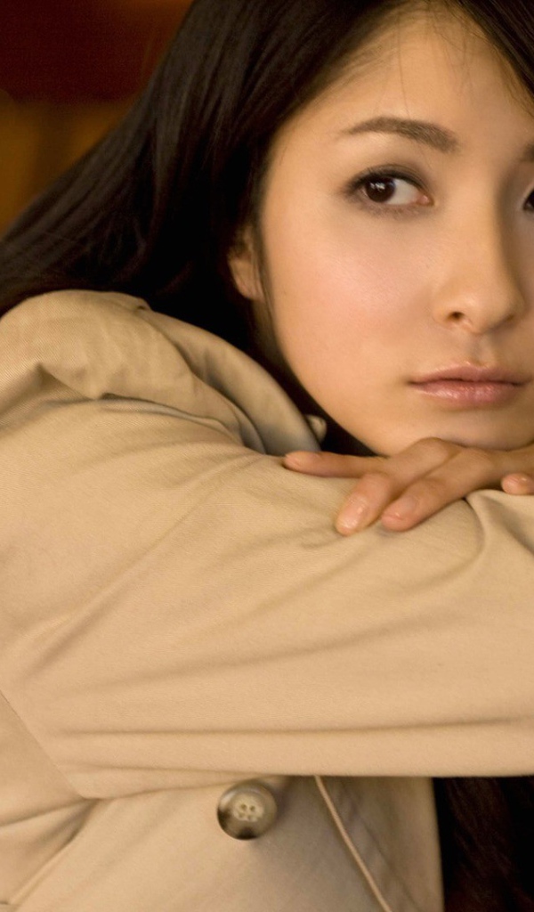 Грустная азиатская девушка в коричневом плаще