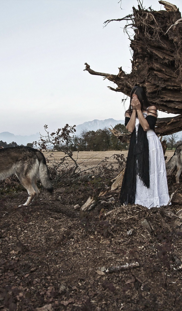 Девушка закрыла лицо в окружении волков