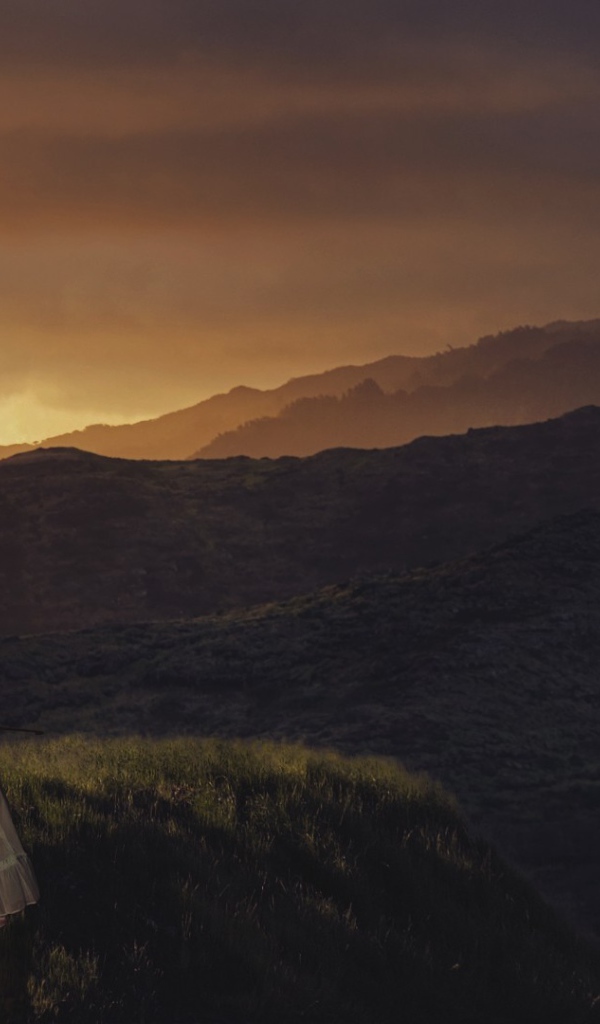 Девушка играет на виолончели на фоне гор