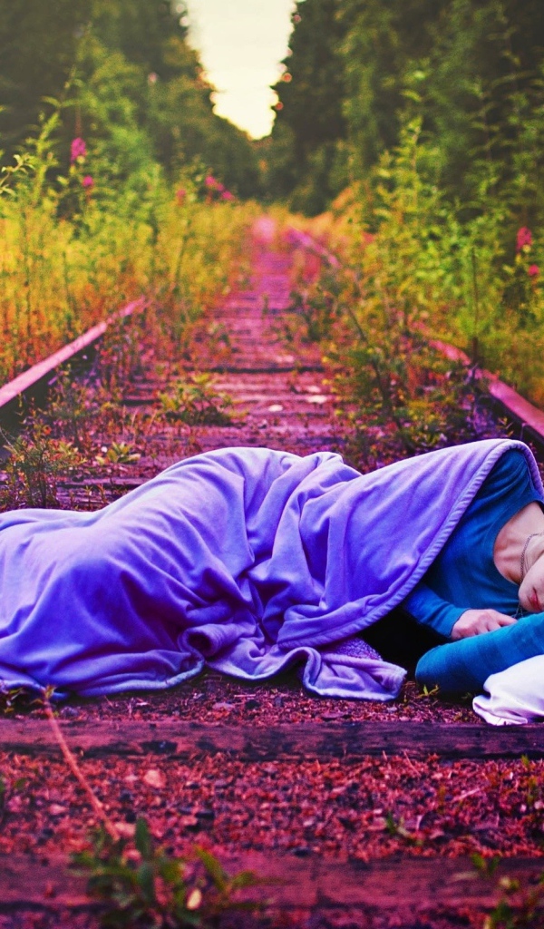 Девушка спит на заброшенных рельсах