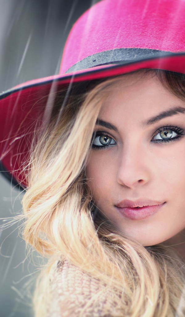 Блондинка в розовой шляпе под дождем