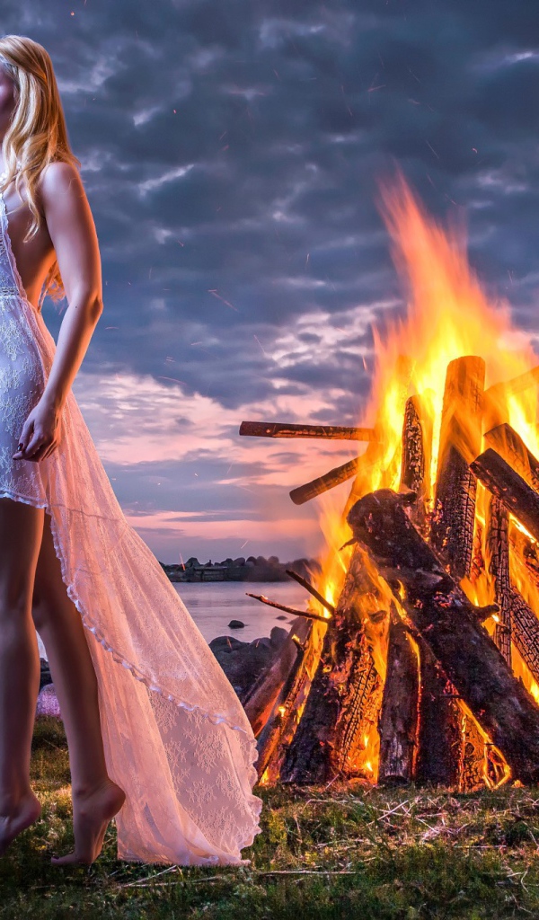 Девушка у костра на берегу океана