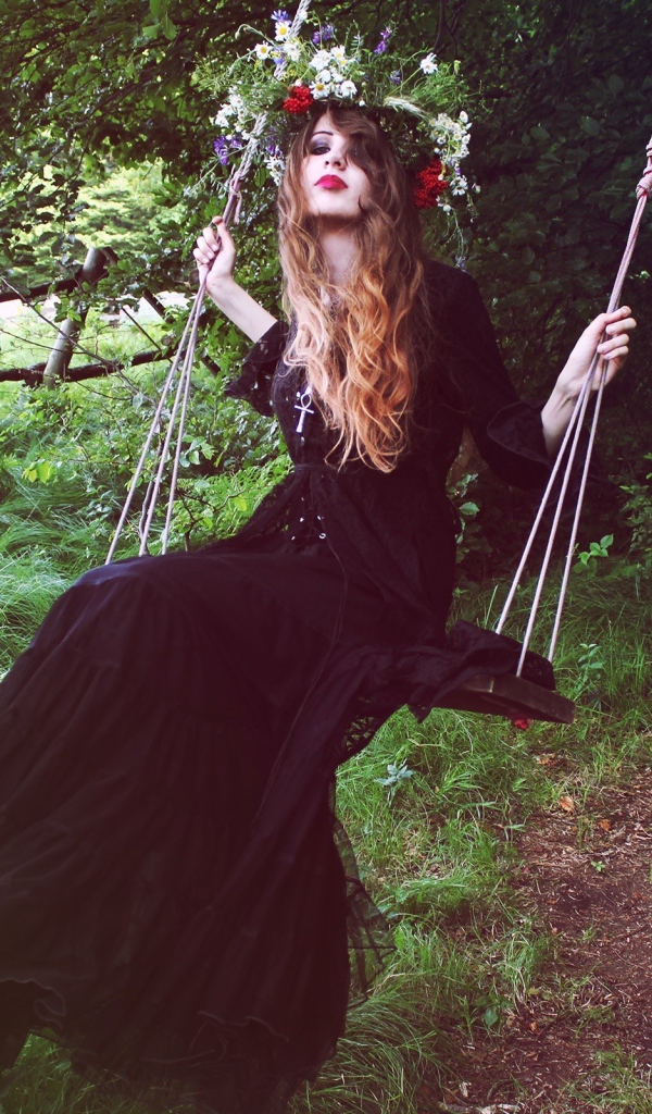 Девушка в черном платье на качели