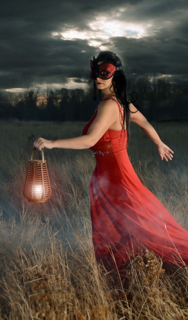 Девушка в красном платье с фонарем в поле