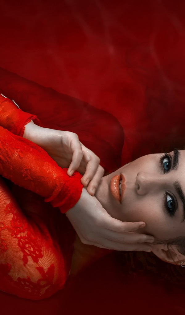 Девушка в красном кружевном платье на красном фоне