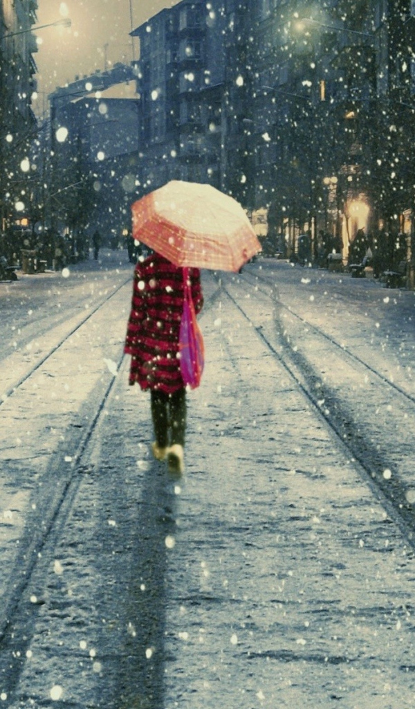 Девушка под дождем идет вдаль по улице