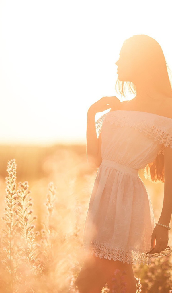 Девушка в лучах яркого летнего солнца