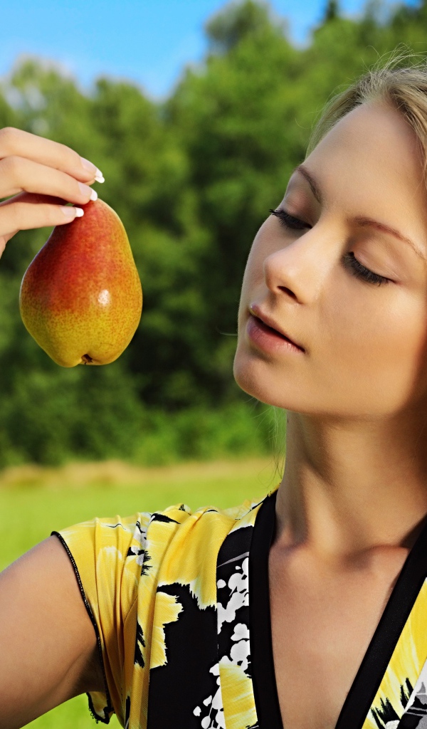 Девушка смотрит на грушу