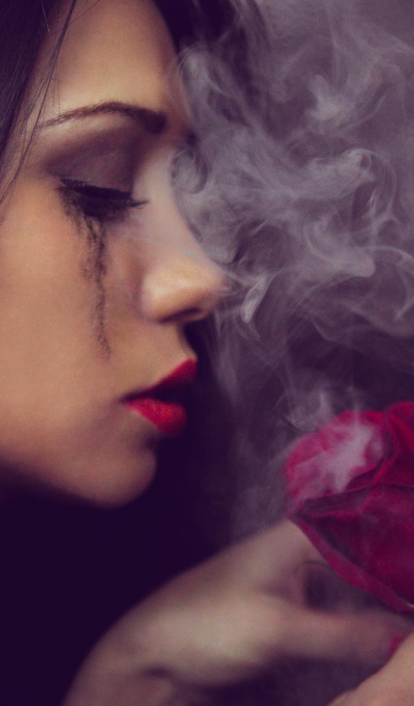 Девушка смотрит на дымящуюся розу