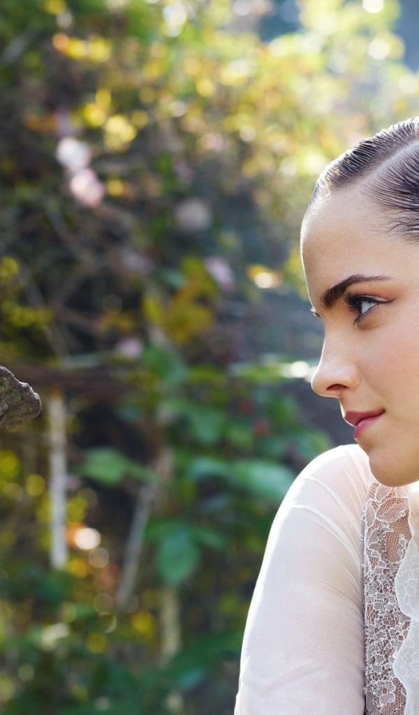 Девушка смотрит на скульптуру в саду