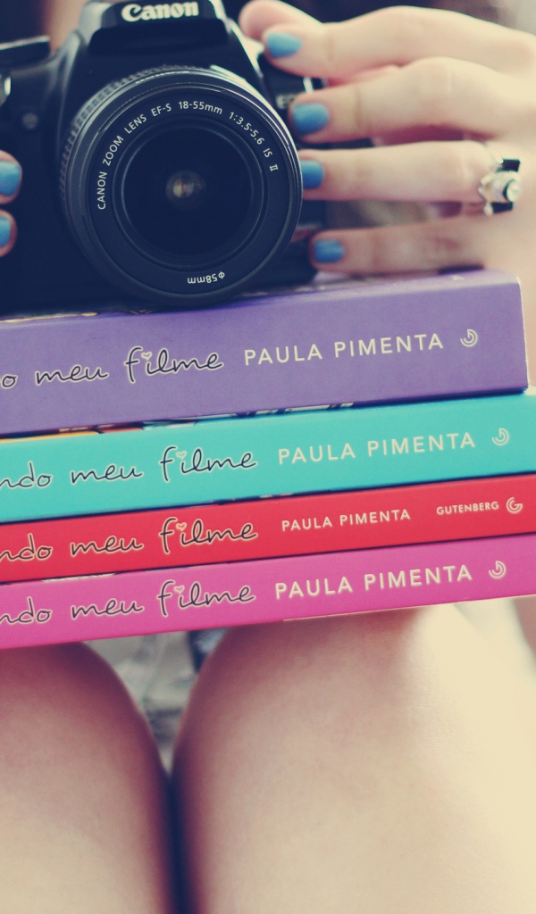 Девушка фотограф со стопкой книг