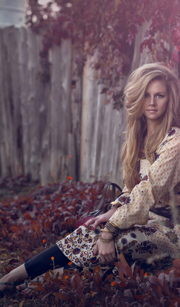 Девушка присела у забора