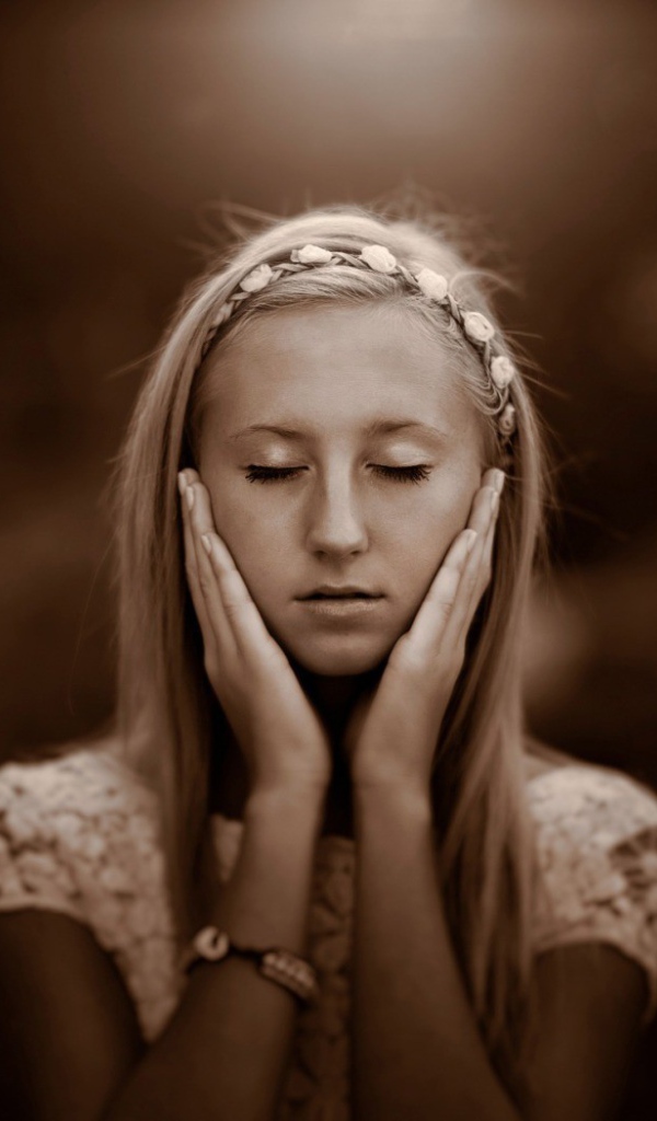 Девушка прикоснулась руками к лицу