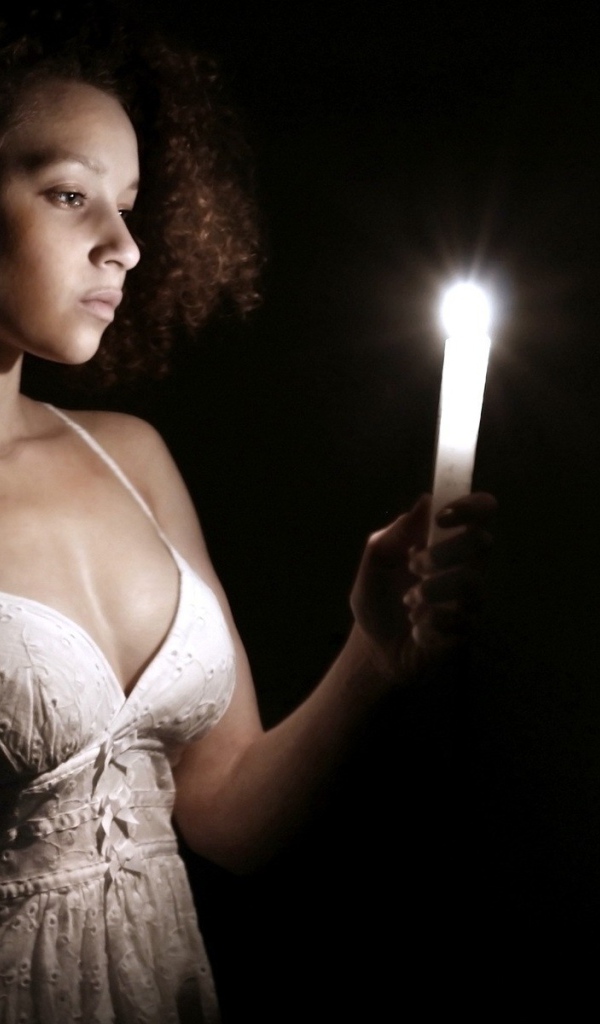 Девушка со свечой в темноте