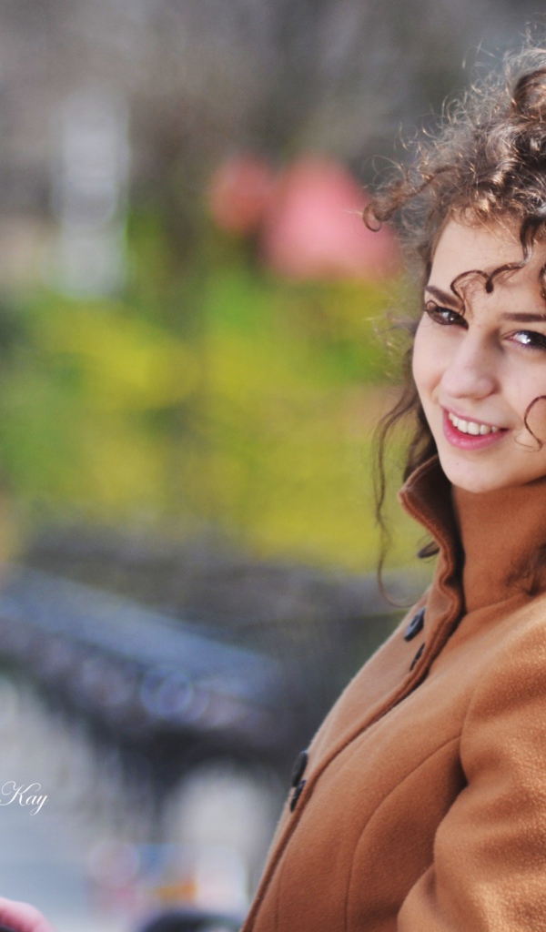 Ветер треплет волосы кучерявой девушки