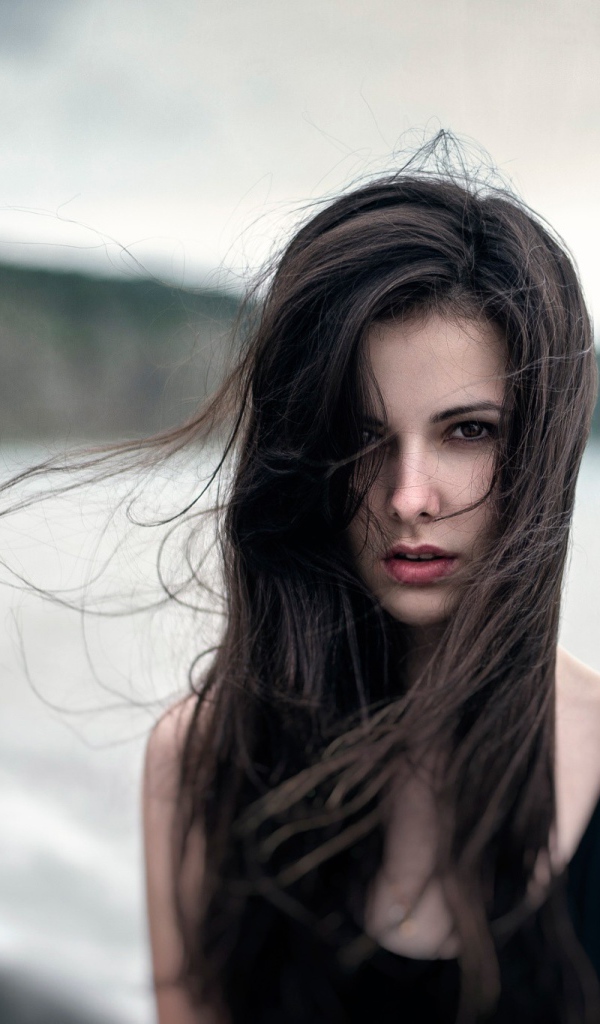 The wind ruffled the girl's hair by the sea, portrait