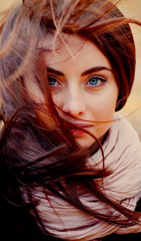 Ветер треплет волосы у девушки