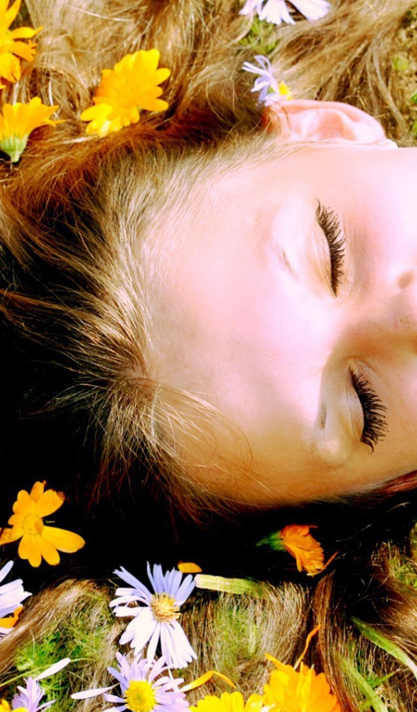 Белые и желтые цветы в волосах у девушки