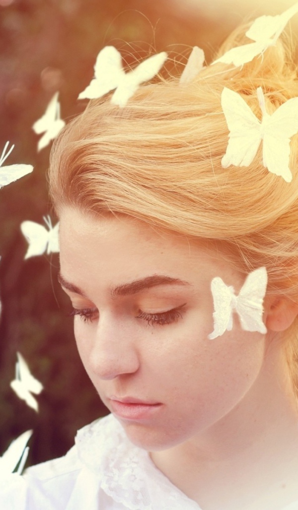 Белые бабочки летают вокруг девушки